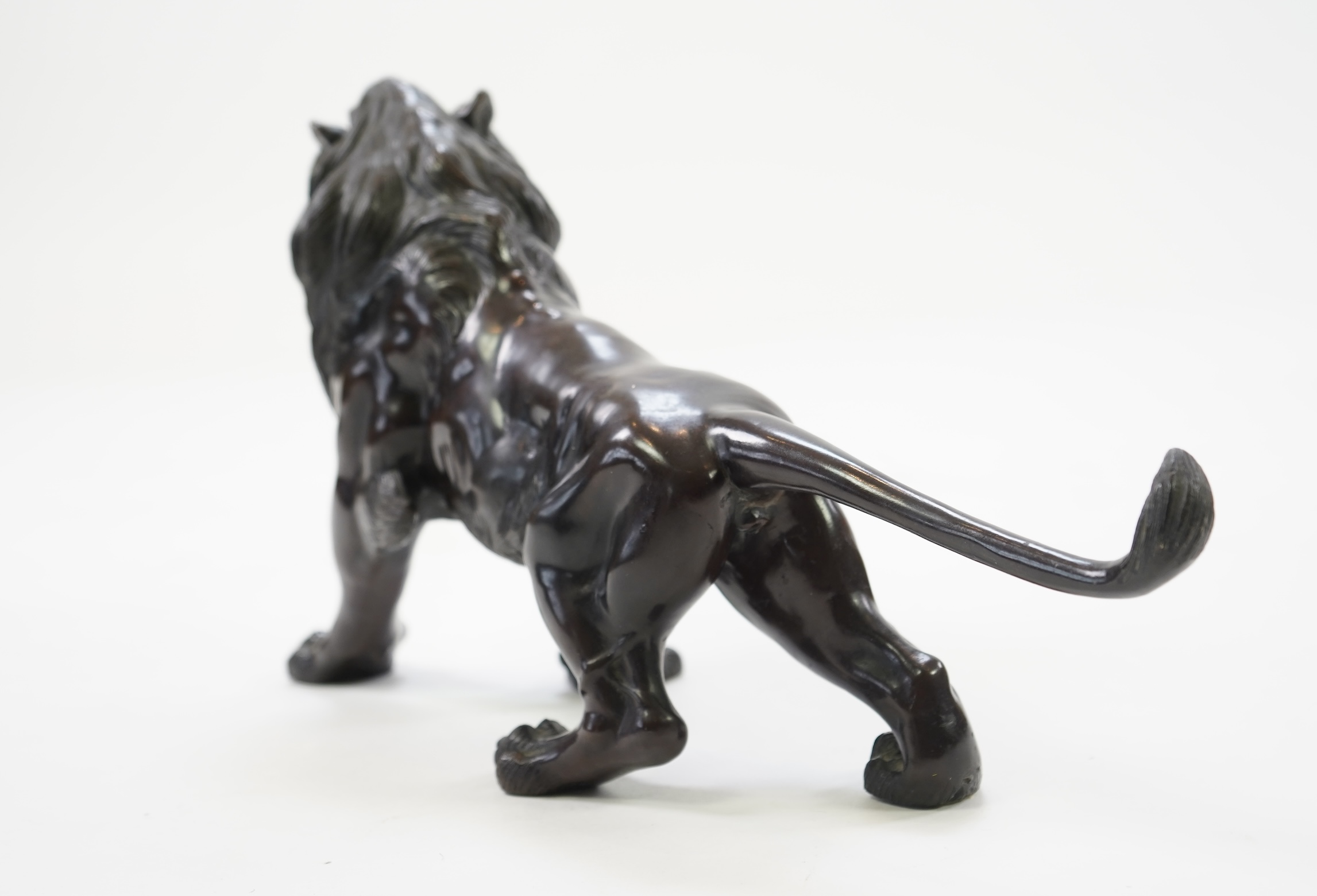 A Japanese patinated bronze okimono of a roaring lion, Meiji period